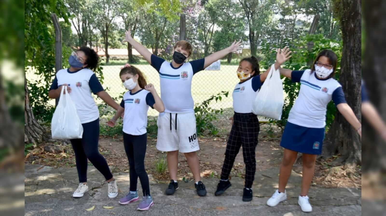 Cinco crianças fazendo pose para a foto com seus uniformes escolares de Jundiaí