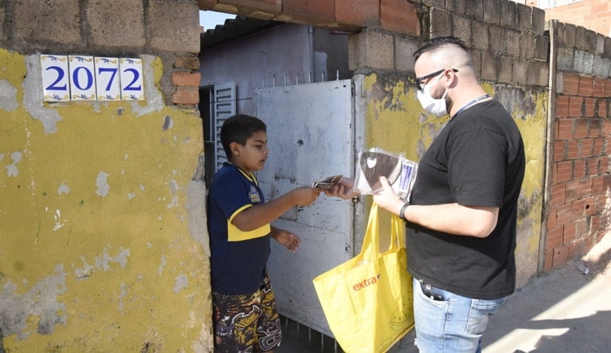 Foto de criança recebendo máscara de tecido