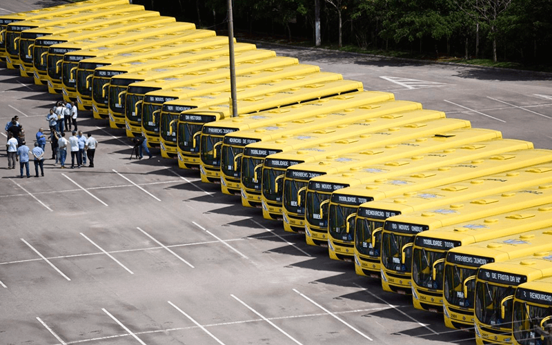 Ônibus enfileirados um do lado do outro; imagem vista de cima