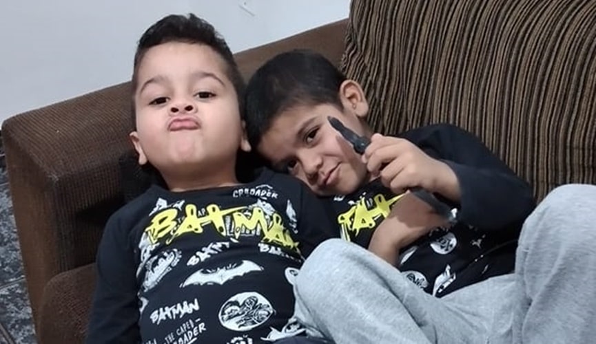 Foto de dois meninos gêmeos em sofá