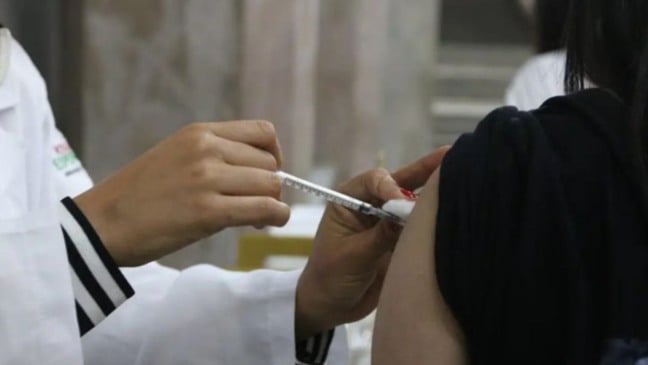 Pessoa recebendo aplicação de vacina