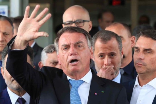 Bolsonaro gesticula durante pronunciamento público cercado por aliados