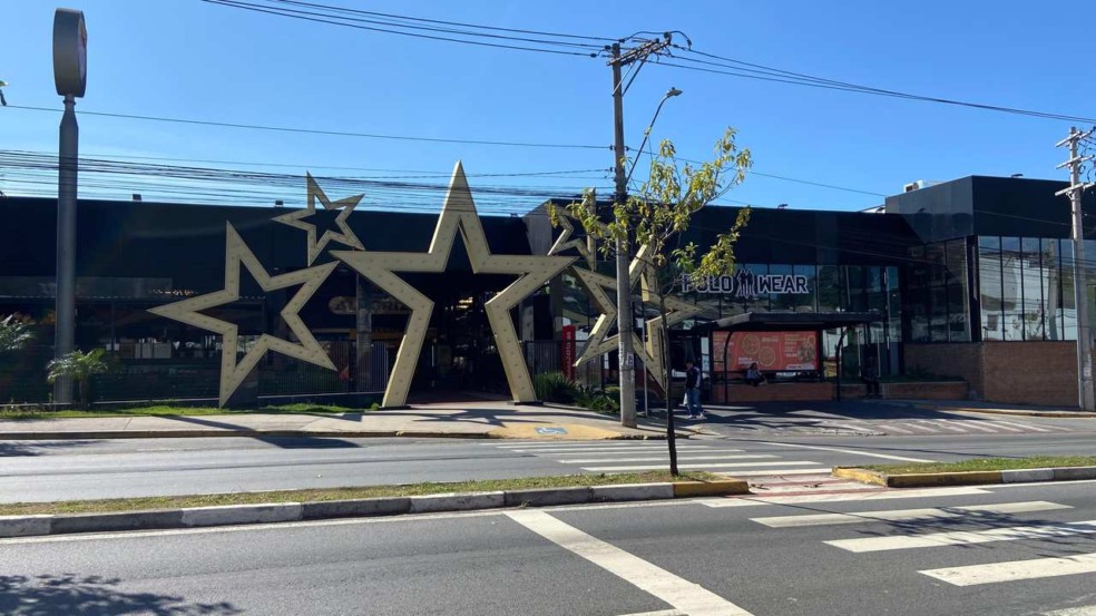 Fachada do Alegria Shopping com grandes estrelas douradas e letreiro 'POLO WEAR'. Fachada do Alegria Shopping com grandes estrelas douradas e letreiro 'POLO WEAR'.
