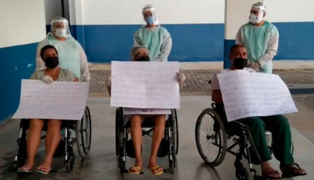 Família segurando cartazes na saída do Hospital