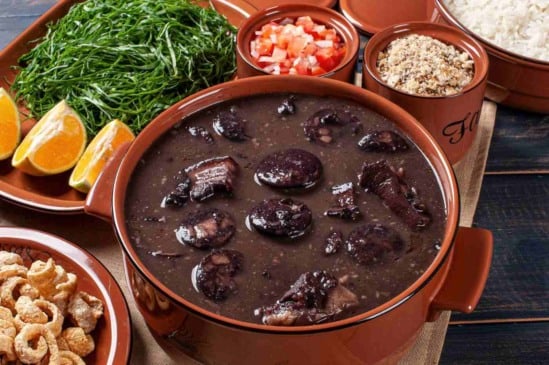 Típica feijoada, com os acompanhamentos tradicionais: arroz branco, couve, torresmo, vinagrete e farora