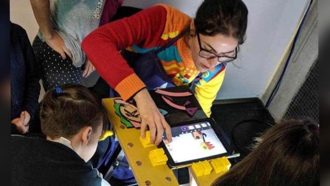Mulher com um tablet e crianças em volta
