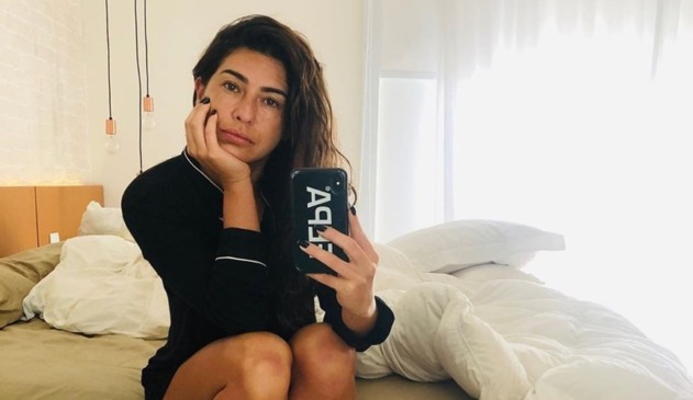 Foto da atriz Fernanda Paes Leme sentada em cama