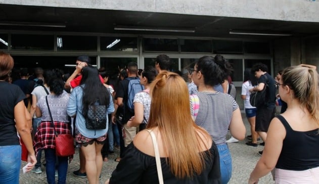 Foto de pessoas em portaria de colégio