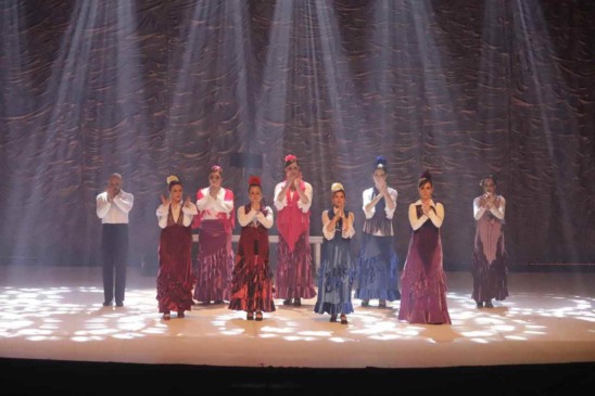 Espetáculo Sons y Sonidos: dançarinas e dançarino em trajes flamencos se apresentando sob luzes no palco da Sala Glória Rocha.