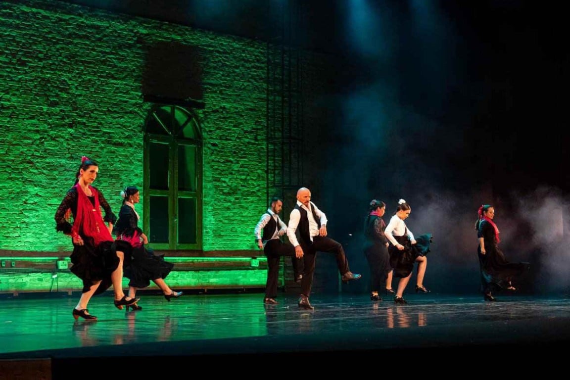 Espetáculo Sons y Sonidos: dançarinos flamencos em coreografia vibrante com fundo iluminado em verde na Sala Glória Rocha, Jundiaí.