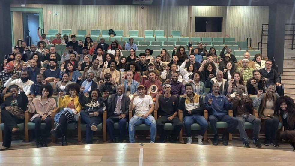 Participantes do Fórum de Promoção da Igualdade Racial em Jundiaí posam para foto em auditório.