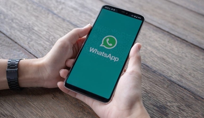 Foto de mãos segurando celular na tela do whatsapp