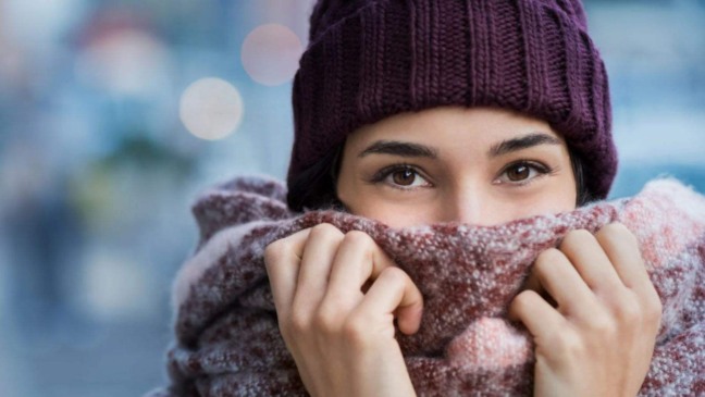 Mulher agasalhada devido às fortes temperaturas.