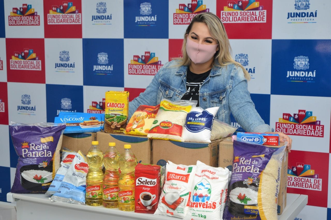 Foto de menina ao lado de cesta básica