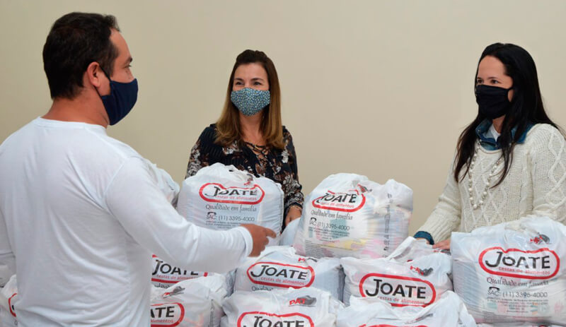 Primeira dama e representantes do Kiosque Roseira com cestas básicas