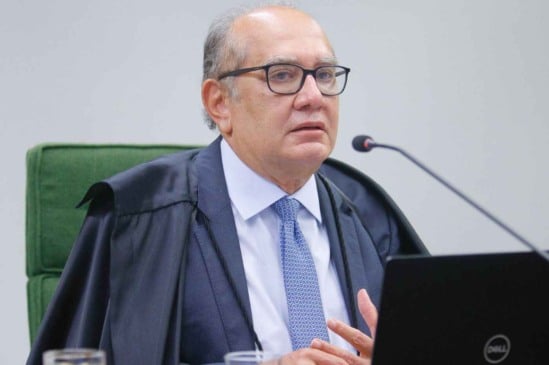 Gilmar Mendes durante sessão do STF, usando toga e falando ao microfone