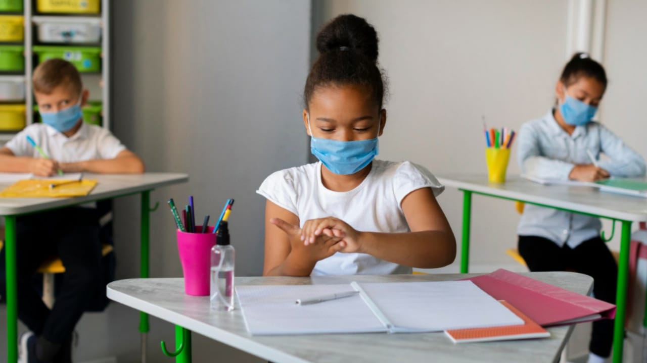 Crianças com máscara em sala de aula