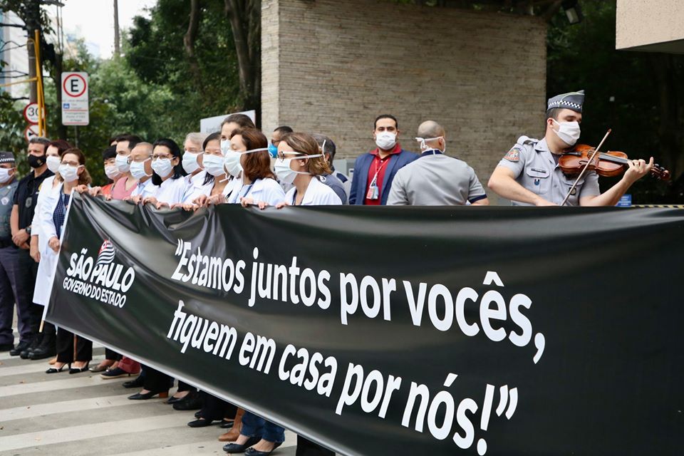 Foto de médicos com cartazes durante homenagem realizada