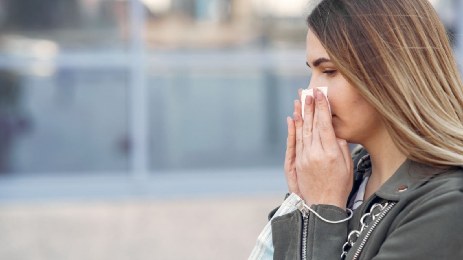 Mulher limpando o nariz.