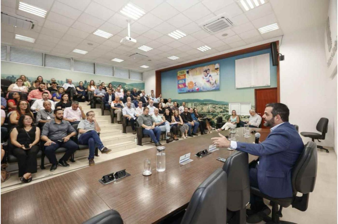 Prefeito Gustavo Martinelli fala a servidores em auditório lotado durante reunião sobre gestão e valorização de funcionários. Prefeito Gustavo Martinelli fala a servidores em auditório lotado durante reunião sobre gestão e valorização de funcionários.