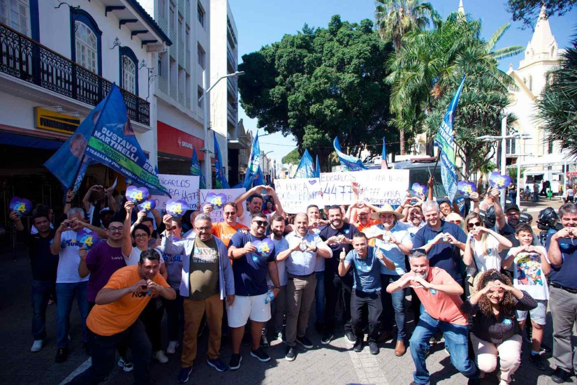 Gustavo Martinelli e apoiadores iniciam caminhada de campanha no Centro de Jundiaí, segurando bandeiras e fazendo gestos de coração.