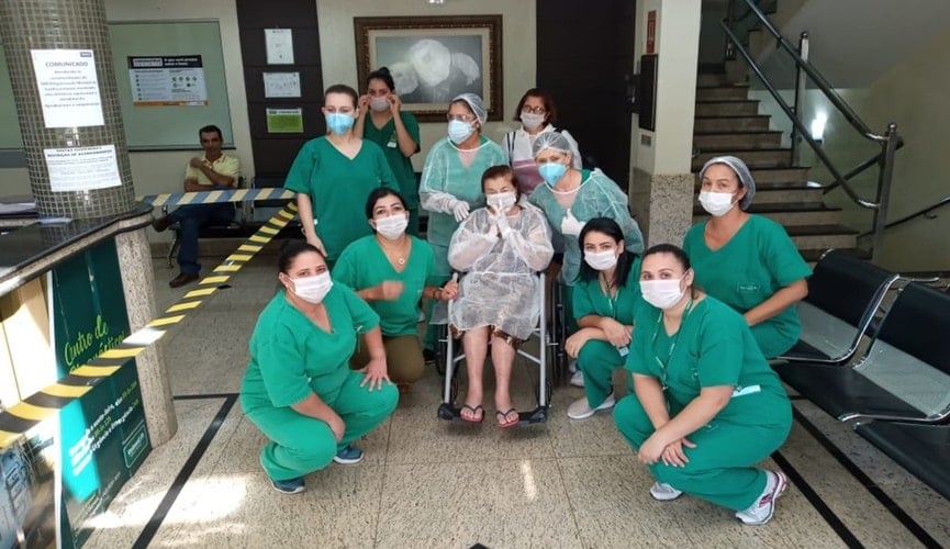 Idosa com equipe médica