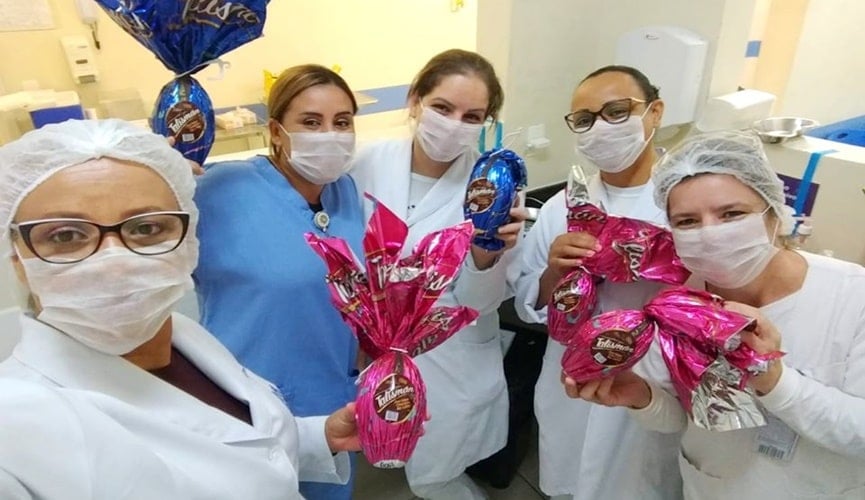 Profissionais de saúde segurando ovos de Páscoa