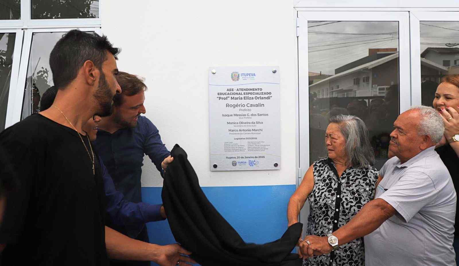 Autoridades e familiares inaugurando a placa do prédio do Atendimento Educacional Especializado de Itupeva, homenageando Maria Eliza Orlandi.