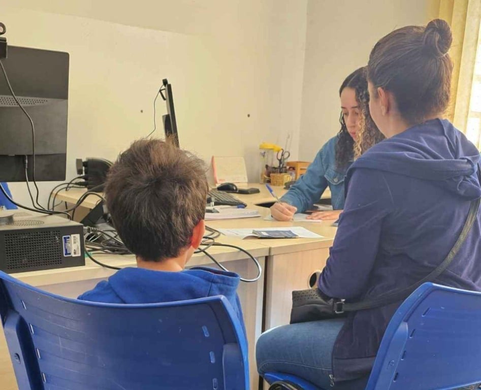 Atendimento de inclusão socioprodutiva em Jundiaí: mãe e filho conversam com assistente social para obter benefícios e apoio.