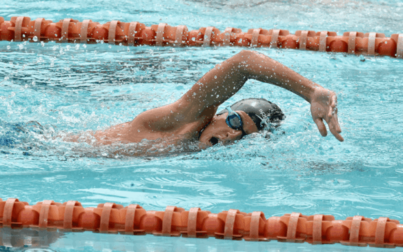 Criança nada crawl em piscina