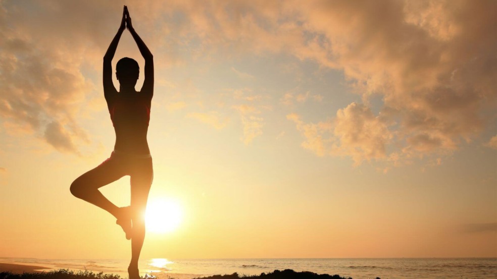 Pessoa praticando yoga em pôr do sol