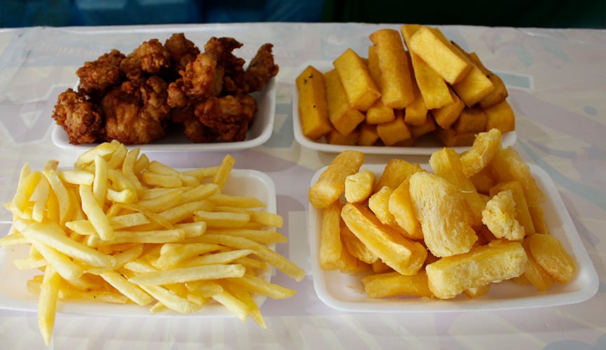 Batata frita, mandioca, polenta e frango frito em bandeijas