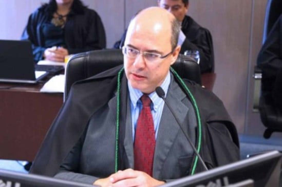 Juiz federal Wilson José Witzel, de terno e capa preta, fala em microfone durante sessão; destaque na política do Rio de Janeiro