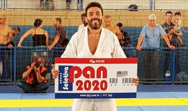 O atleta Leko Okada segura placa simbólica que garante seu acesso ao Pan 2020