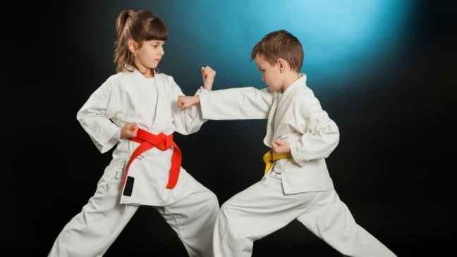 duas crianças lutando karatê