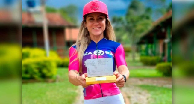 Ciclista jundiaiense Lais Saes segurando um trofeu em espaço aberto ao ar livre