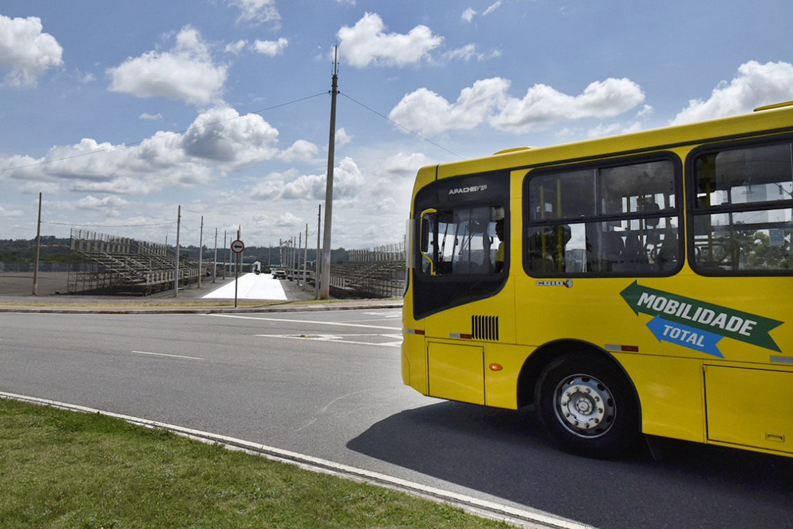 ônibus amarelo trafegando em rua