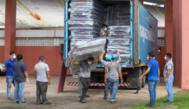 Foto de colchões sendo descarregados de caminhão