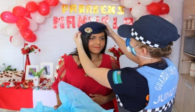 Foto de guarda colocando boina em adolescente