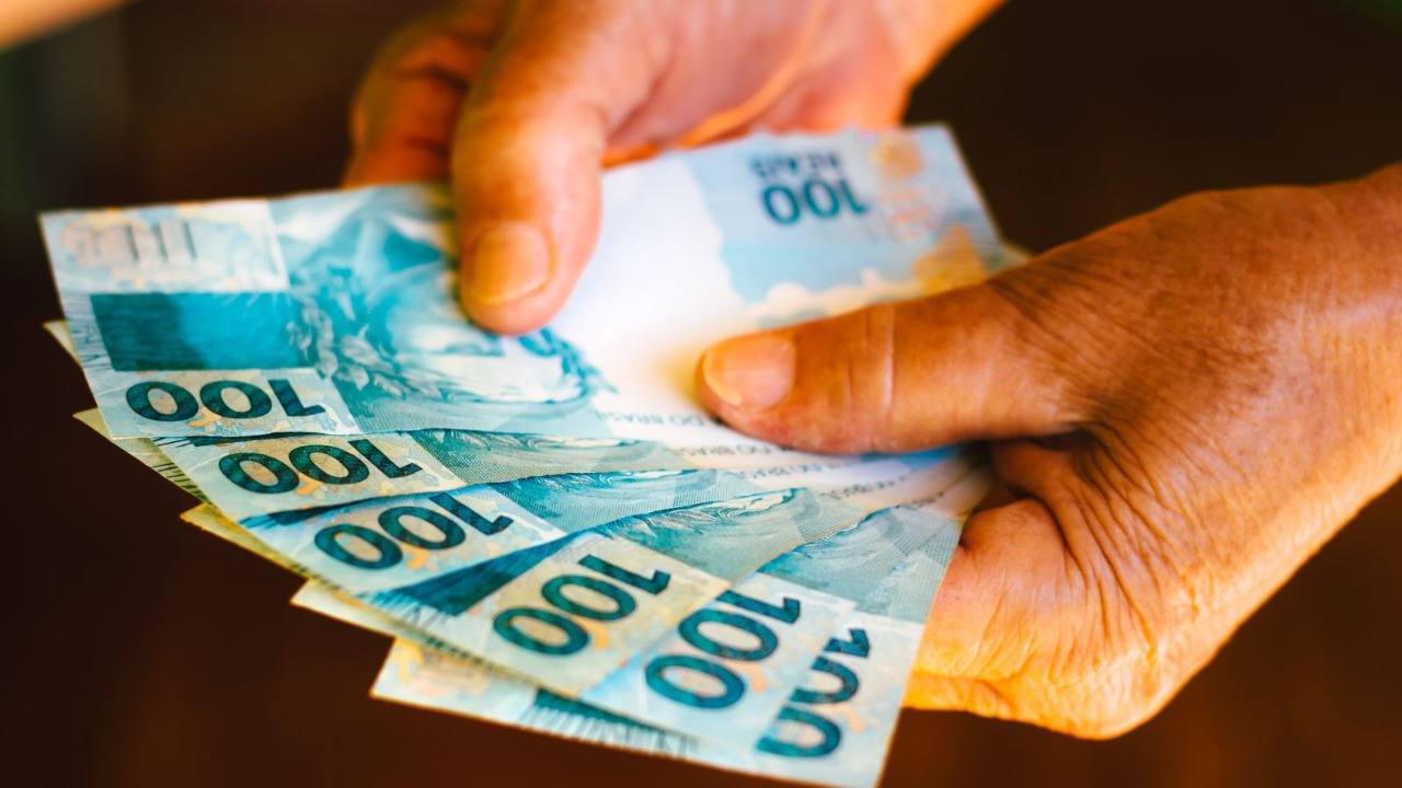 mão-segurando-cédulas-de-dinheiro-compressed