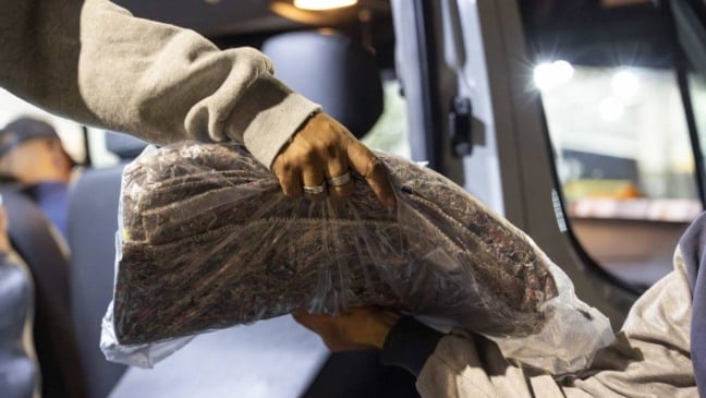 Mãos entregando cobertores para pessoas em situação de rua em Jundiaí.