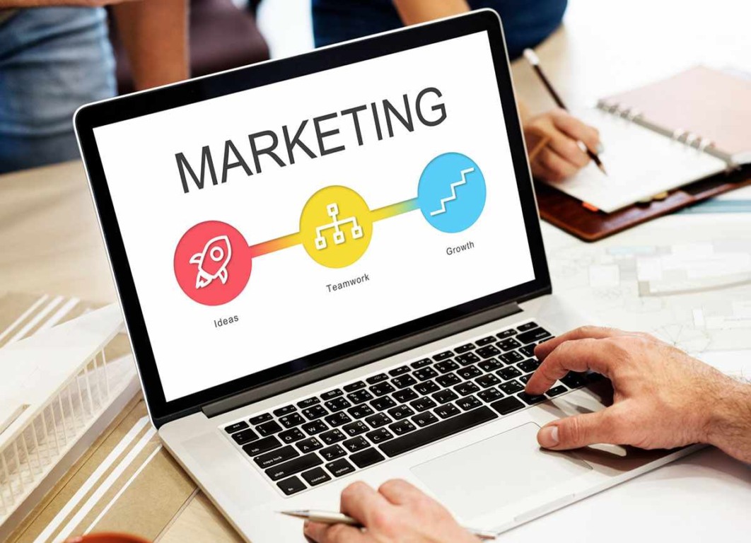 Pessoa digital em um notebook sobre uma mesa, informações sobre marketing digital