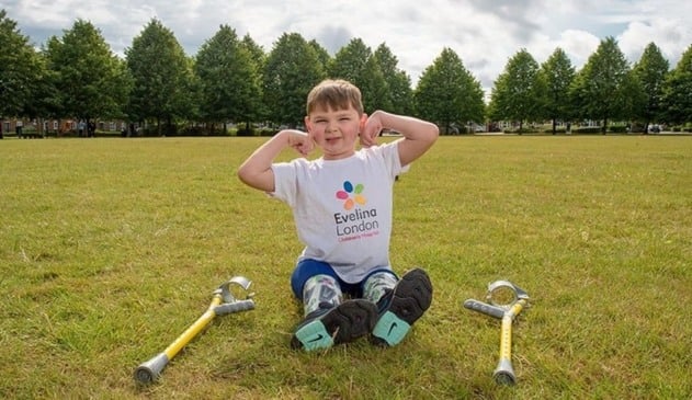 Foto de menino com próteses de pernas