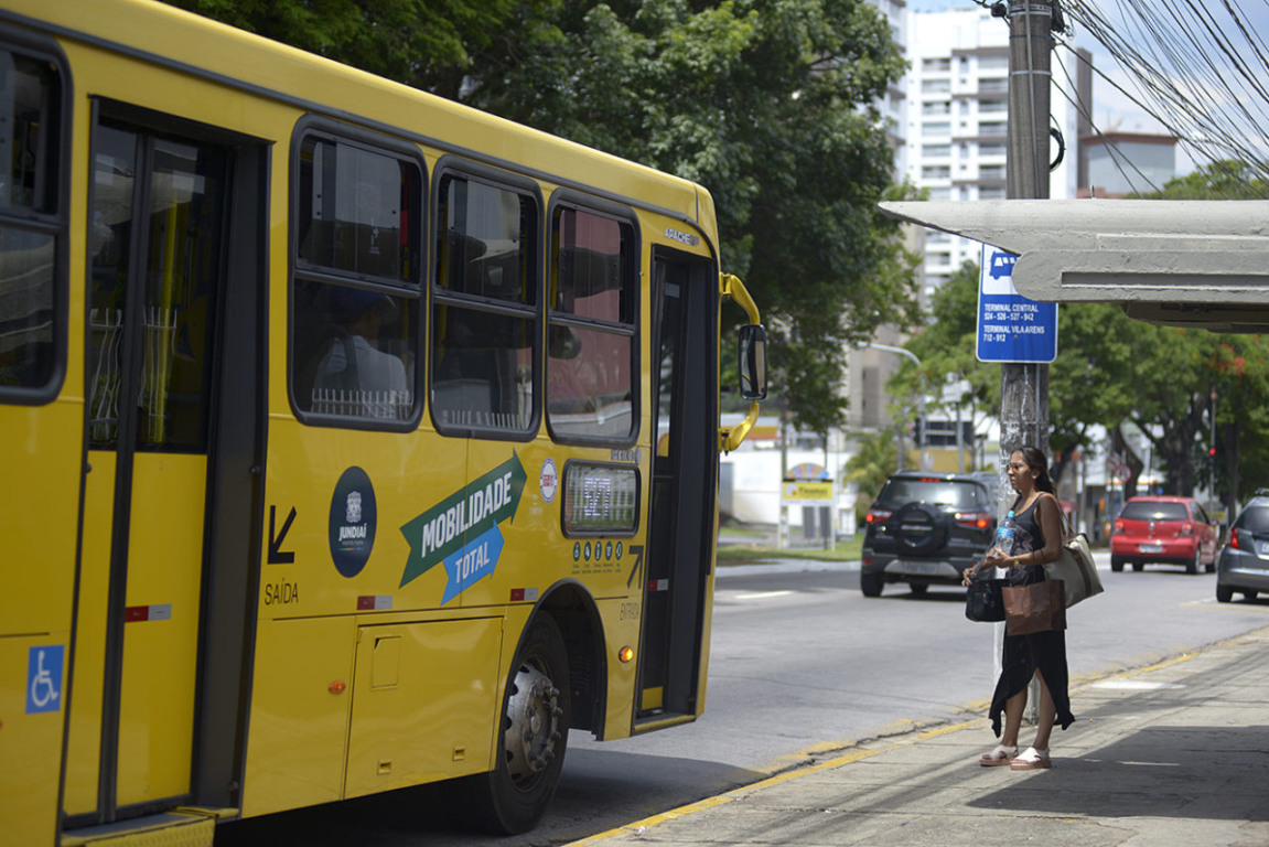 onibus parado no ponto para perto de uma mulher