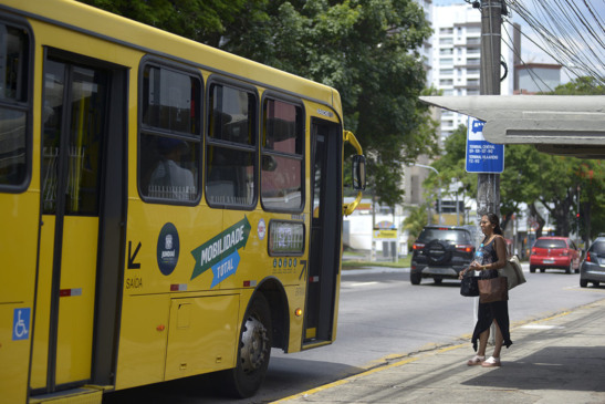 onibus parado no ponto para perto de uma mulher