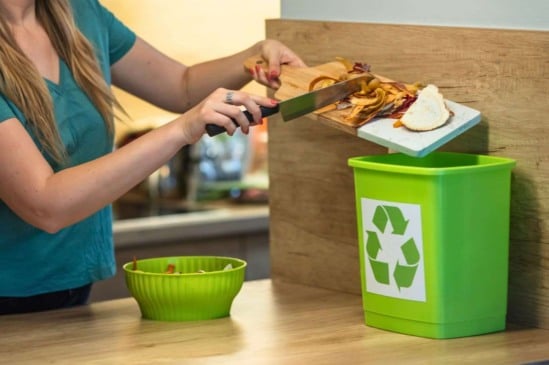 Mulher fazendo compostagem a partir de resíduos orgânicos da cozinha