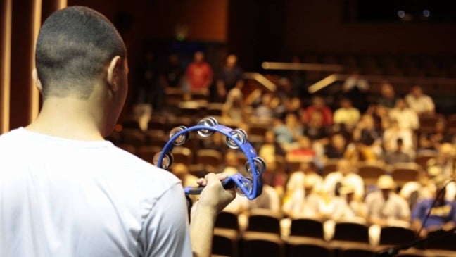 Adolescente toca pandeiro durante apresentação do Festival de Música da Fundação CASA no SESC Jundiaí.