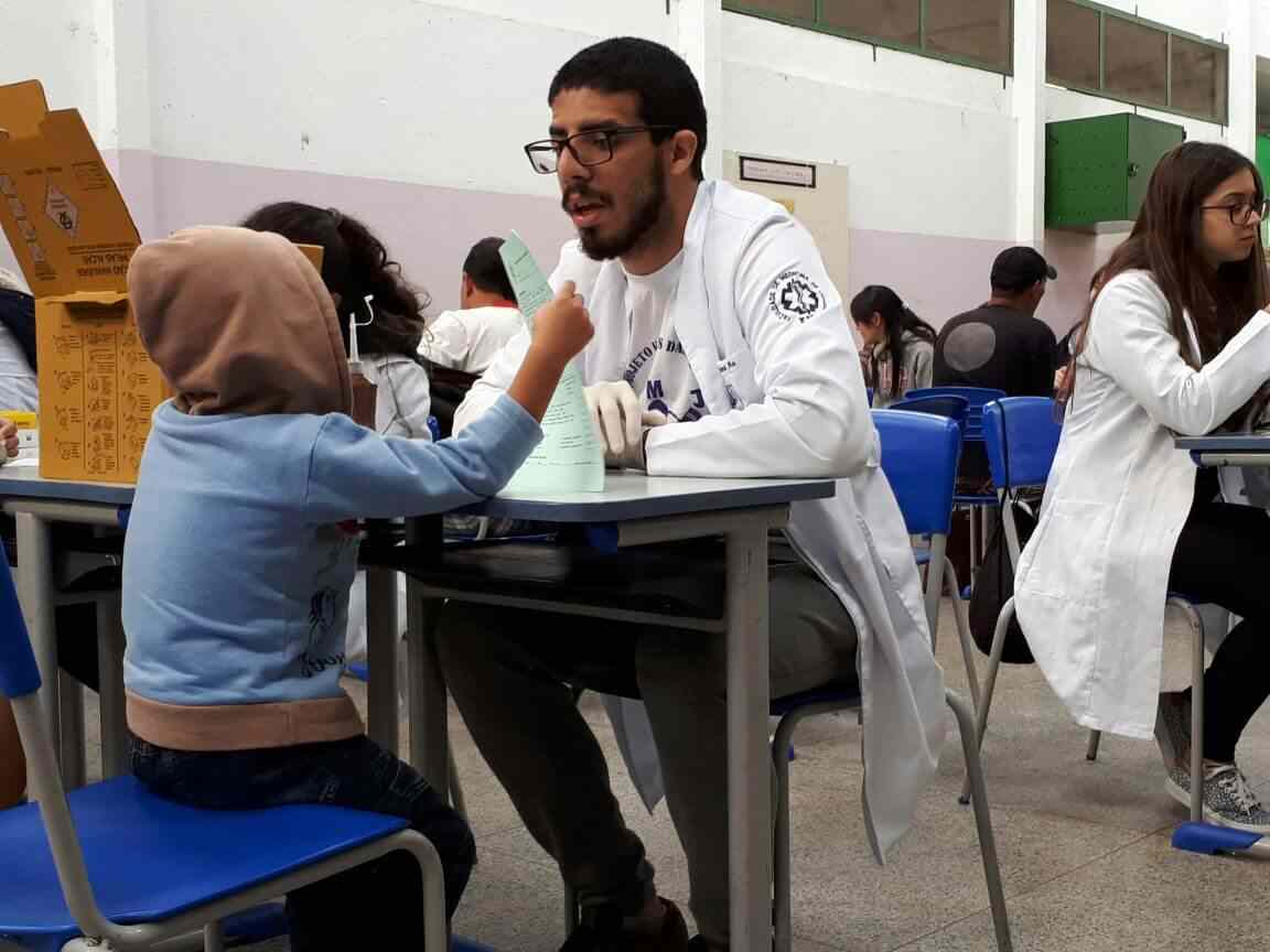 Aluno de Medicina da Faculdade de Jundiaí fazendo atendimento a uma criança