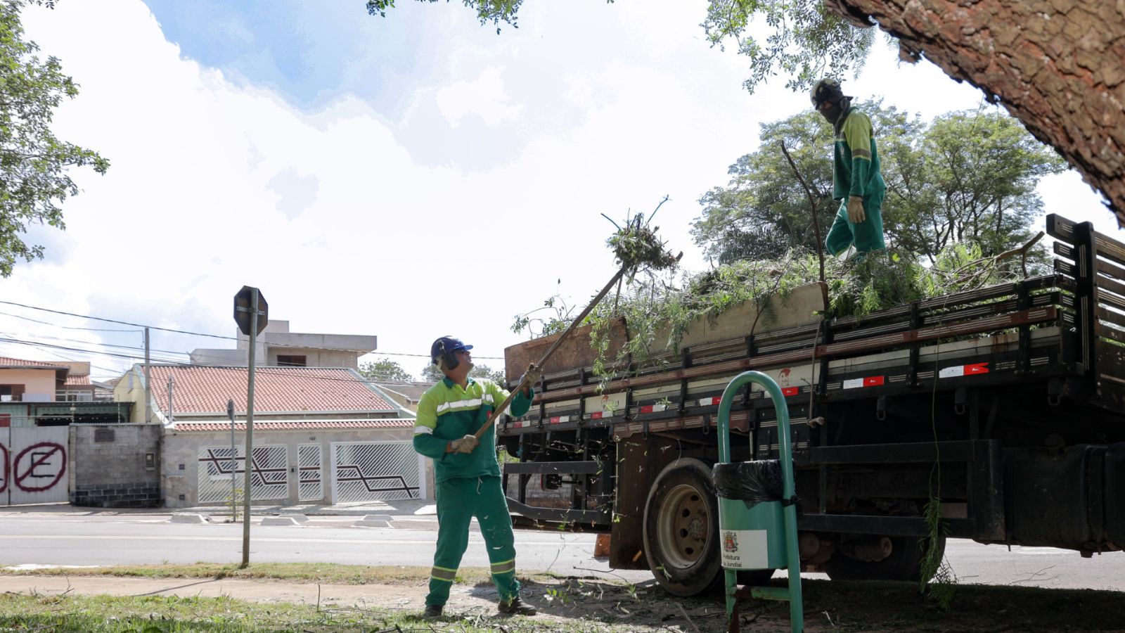 Servidor colocando galhos em caminhão.