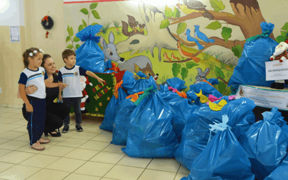 Duas crianças e professora observam montante arrecadado
